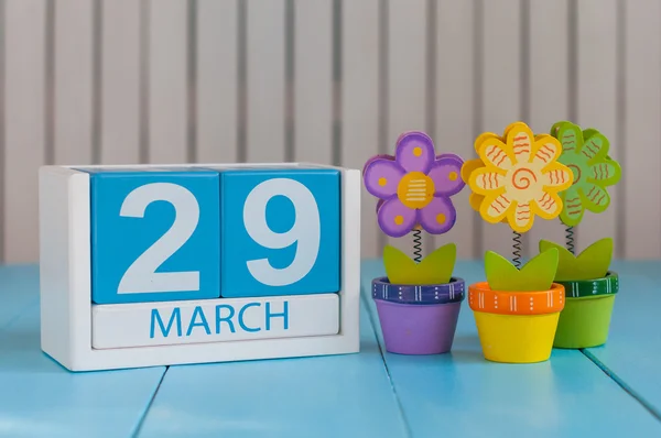 29 marca. Kalendarz sześcienny na 29 marca na drewnianej powierzchni z kwiatami i pustą przestrzenią dla tekstu — Zdjęcie stockowe