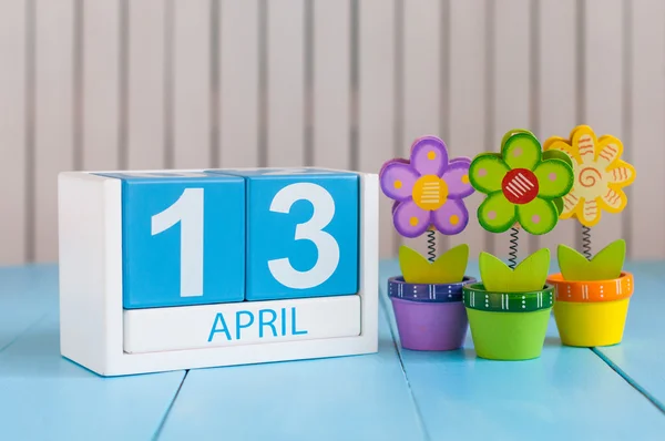 13. April. Bild vom 13. April hölzerner Farbkalender auf weißem Hintergrund mit Blumen. Frühlingstag, leerer Raum für Text. Welt-Rock-n-Roll-Tag — Stockfoto