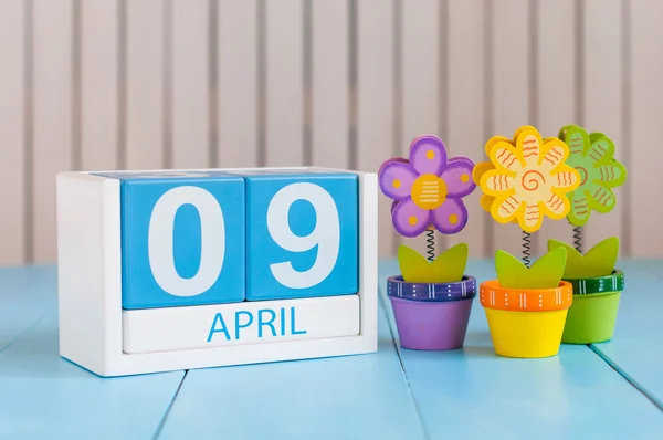 9 de abril. Imagen de 9 de abril calendario de color madera sobre fondo blanco con flores. Primavera de Europa, espacio vacío para texto — Foto de Stock