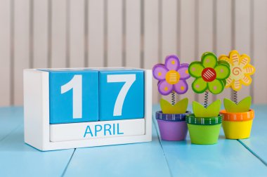 April 17th. Image of april 17 wooden color calendar on white background with flowers. Spring day, empty space for text. Tax Deadline