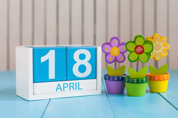 18. April. Bild vom 18. April Holzfarbkalender auf weißem Hintergrund mit Blumen. Frühlingstag, leerer Raum für Text. Internationaler Tag für Denkmäler und Amateurfunk — Stockfoto