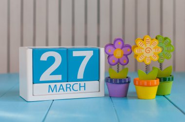 27 Mart. Çiçeklerle beyaz arka plan üzerinde 27 Mart ahşap renkli takvim Görüntüsü. Bahar günü, metin için boş alan. Dünya Tiyatro Günü