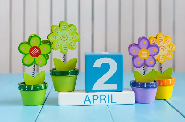 Il 2 aprile. Immagine di 2 aprile calendario a colori in legno su sfondo bianco con fiori. Giorno di primavera, spazio vuoto per il testo. Giornata internazionale del libro per bambini — Foto Stock