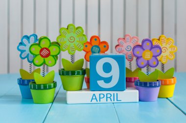 April 9th. Image of april 9 wooden color calendar on white background with flowers.  Spring day, empty space for text