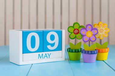 May 9th. Image of may 9 wooden color calendar on white background with flowers. Spring day, empty space for text.  Symbols Of the victory in World War II