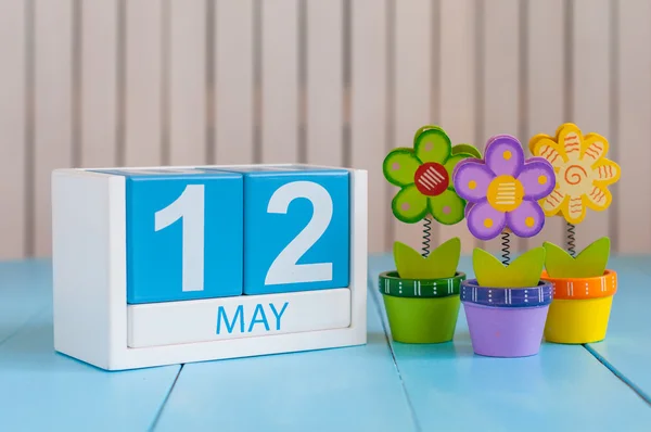 12th Μαίου. Εικόνα του Μαΐου 12 ξύλινο ημερολόγιο σε λευκό φόντο με λουλούδια. Ημέρα της άνοιξης, κενός χώρος για κείμενο. Διεθνής ημέρα νοσηλευτριών — Φωτογραφία Αρχείου