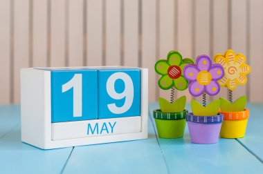 May 19th. Image of may 19 wooden color calendar on white background with flowers. Spring day, empty space for text