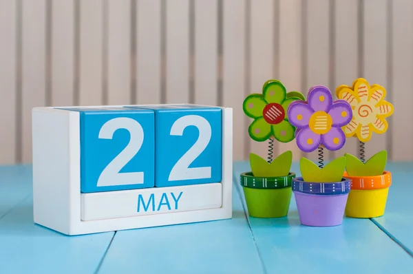 22 травня. Зображення 22 травня дерев'яного кольорового календаря на білому тлі з квіткою. Весняний день, порожнє місце для тексту — стокове фото