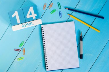 14 Nisan. Mavi arka plan üzerinde 14 Nisan ahşap renkli takvim görüntüsü. Bahar günü, metin için boş alan