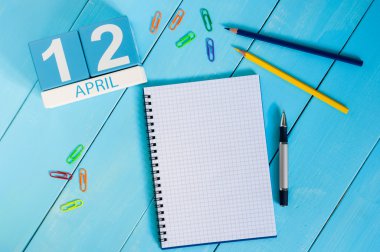 12 Nisan. Mavi arka plan üzerinde 12 Nisan ahşap renkli takvim görüntüsü. Bahar günü, metin için boş alan. Havacılık ve Kozmonotluk Günü. Uluslararası İnsanlık Uzay Uçuşu Günü