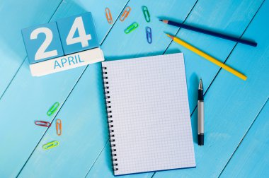 24 Nisan. Mavi arka plan üzerinde 24 Nisan ahşap renkli takvim görüntüsü. Bahar günü, metin için boş alan. Dünya Bağışıklama Haftası