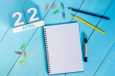 22 Nisan. Dünya Günü. Mavi arka plan üzerinde 22 Nisan ahşap renkli takvim görüntüsü. Bahar günü, metin için boş alan