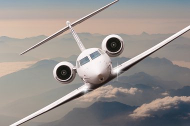 Bulutlar ve günbatımı dağda Alpler üzerinden uçak fly. Bir büyük yolcu ve yük uçak, iş jeti, havayolu önden görünümü. Ulaşım, seyahat kavramı