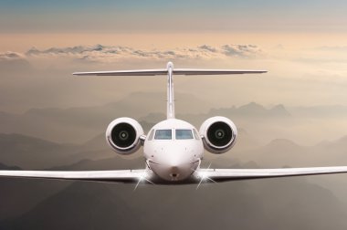 Bulutlar ve günbatımı dağda Alpler üzerinden uçak fly. Bir büyük yolcu ve yük uçak, iş jeti, havayolu önden görünümü. Ulaşım, seyahat kavramı