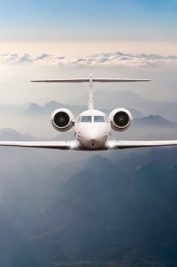 Bulutlar ve günbatımı dağda Alpler üzerinden uçak fly. Bir büyük yolcu ve yük uçak, iş jeti, havayolu önden görünümü. Ulaşım, seyahat kavramı
