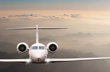 Bulutlar ve günbatımı dağda Alpler üzerinden uçak fly. Bir büyük yolcu ve yük uçak, iş jeti, havayolu önden görünümü. Ulaşım, seyahat kavramı
