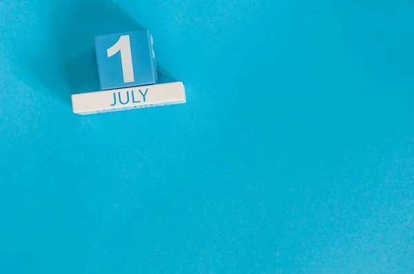 Le 1er juillet. Image de juillet 1 calendrier de couleurs en bois sur fond bleu. Jour d'été. Espace vide pour le texte — Photo
