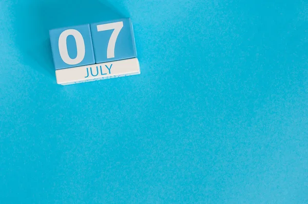 7 de julio. Imagen de 7 de julio calendario de color madera sobre fondo azul. Día de verano. Espacio vacío para texto — Foto de Stock