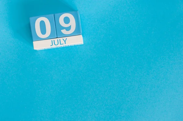 Le 9 juillet. Image de juillet 9 calendrier de couleurs en bois sur fond bleu. Jour d'été. Espace vide pour le texte — Photo