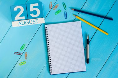 August 25th. Image of august 25 wooden color calendar on blue background. Summer day. Empty space for text clipart