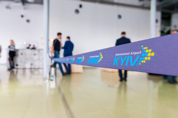 КИЕВ, УКРАИНА - 07 апреля 2016 г.: Международный аэропорт Киев, Жуляны. Стоп-линия или лента с логотипом аэропорта Киев с размытыми людьми
