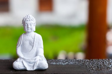 Seramik Zen Buda heykeli bulanık doku arka plan ile meditasyon. Yoga kavramı