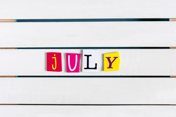 Color dergisi ile yazılmıştır Temmuz kupürleri Beyaz ahşap tahta üzerinde mektup. Yaz tatil kavramı — Stok fotoğraf