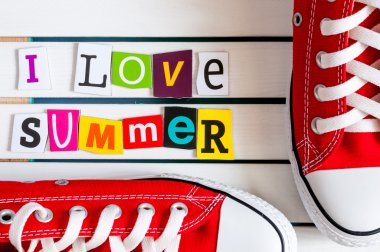 Kırmızı Gymshoes ve ben seviyorum yaz - ahşap tahta üzerinde renk dergisi mektup kupürleri ile yazılı. Yaz tatil kavramı