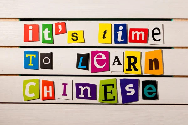 Its time to learn chinese - written with color magazine letter clippings on wooden board. Chinese language learning