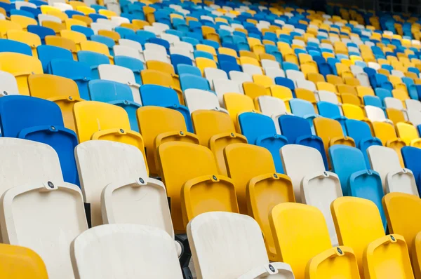 Asientos de plástico vacíos en un estadio de fútbol o fútbol. Fondo deportivo 2016 — Foto de Stock