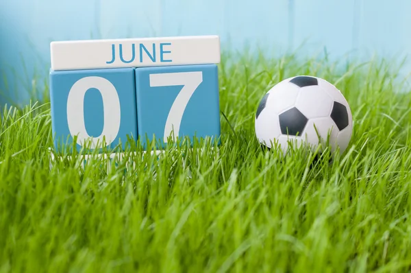 7 czerwca. Obraz z 7 czerwca drewniane kolor kalendarza na tle zielonej trawy z Strój piłkarski. Letni dzień — Zdjęcie stockowe
