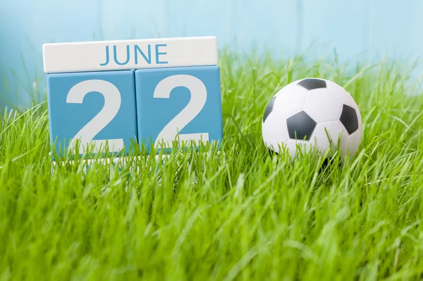 22 czerwca. Obraz z 22 czerwca drewniane kolor kalendarza na tle zielonej trawy z Strój piłkarski. Letni dzień — Zdjęcie stockowe