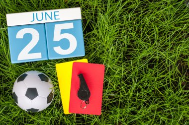 25 Haziran. 25 Haziran görüntüsünü ahşap renk takvim futbol kıyafet yeşil çim zemin üzerine. Yaz günü