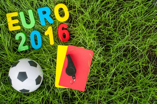 Euro 2016 football championship - image with ball, referee yellow, red card on green lawn. Symbol of soccer and fair play. Empty space for text