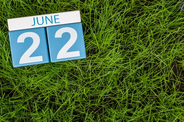 June 22nd. Image of june 22 wooden color calendar on greengrass lawn background. Summer day, empty space for text