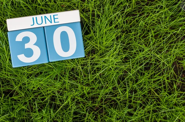 30. Obrázek 30. června dřevěný barevný kalendář na greengrass trávníku pozadí. Letní den, prázdné místo pro text — Stock fotografie