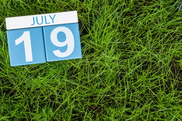 19 juli. Bilden av den 19 juli trä färg kalender på greengrass gräsmatta bakgrund. Sommardag, tomt utrymme för text — Stockfoto