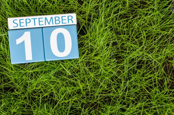 10 вересня. Зображення з 10 вересня дерев'яні колір календар на фоні зелена трава газон. Осінній день. Порожній простір для тексту. Всесвітній день першої допомоги — стокове фото