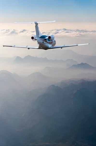 Vista de perspectiva de avión de pasajeros en vuelo con fondo de montañas — Foto de Stock