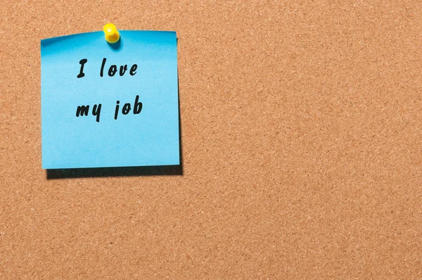 I love my job written on blue adhesive note pinned at notice board background — Stock Photo, Image