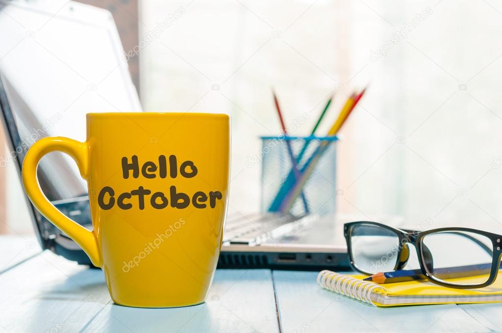 Hello October on morning coffee cup at business office workplace with notepad and glasses