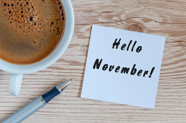 Hola Noviembre. letras dibujadas a mano en el bloc de notas en la mesa con taza de café de la mañana. Vista superior Fotos De Stock