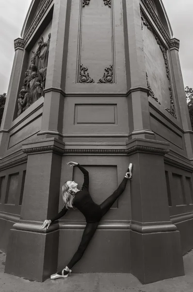 Ballerina on split en pointe near black wall — Stock Photo, Image