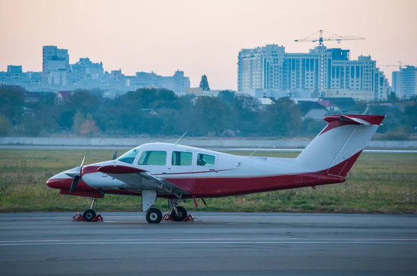 Lätta flygplan på flygplatsen. Planet på bakgrund av staden — Stockfoto