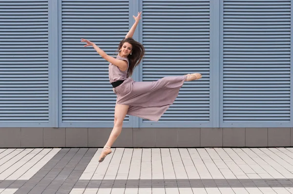 Bailarina dançando em roupas casuais pulando em dedos do pé. Acrobática, ballet, dança. Ao ar livre — Fotografia de Stock