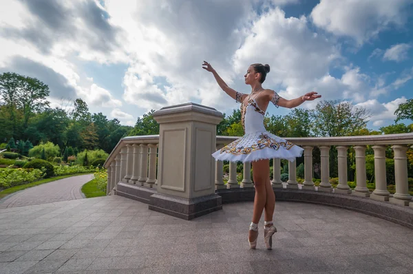 Ballerina dancing near columns, standing in pointe position. Outdoors, spring — Stock Photo, Image