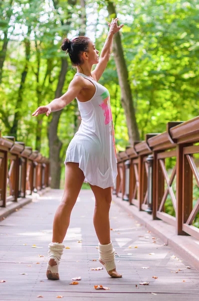 Dançarina fica em bicos de pés, pirueta de balé. Ao ar livre, primavera — Fotografia de Stock