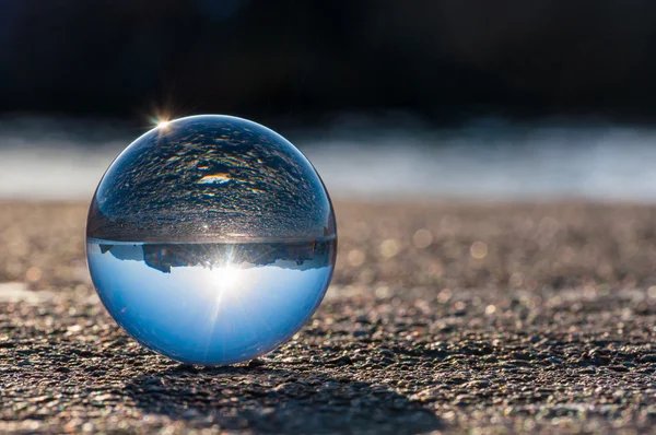 Glass transparent ball on dark background and grainy surface. — Stock Photo, Image