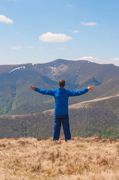 Mountaineer reaches the top of a mountain in sunny spring day. — Stock Photo, Image