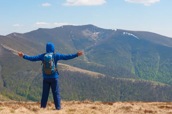 Mountaineer reaches the top of a mountain in sunny spring day. — Stock Photo, Image